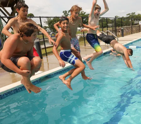 Campers jumping into pool at Camp Sea Gull