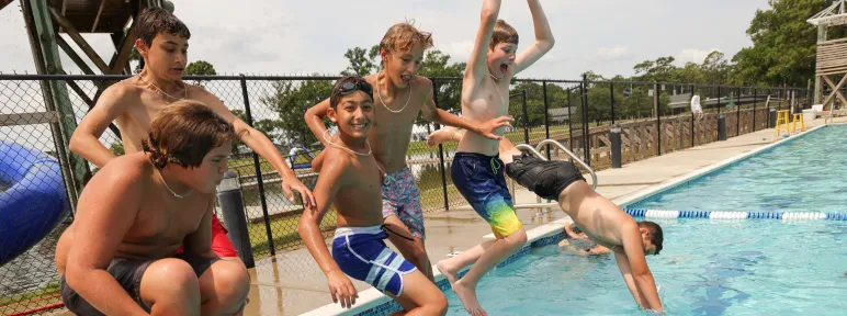 Campers jumping into pool at Camp Sea Gull