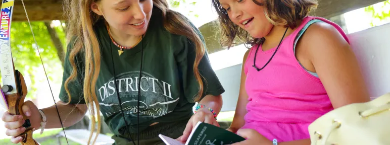 Counselor and camper with green book