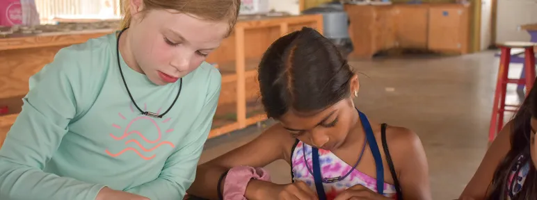 Two girls creating pearler bead artwork