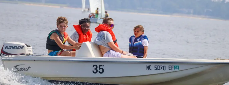 Four boys on a motorboat