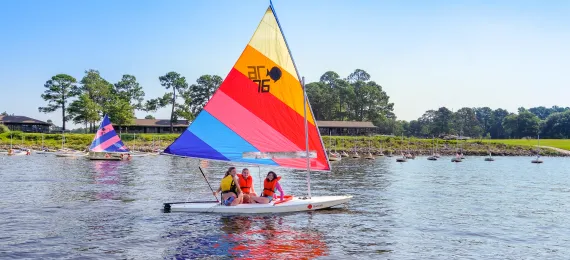 Three girls on a sailboat at Camp Seafarer