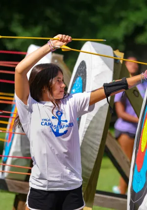 girl pulling arrow out of target