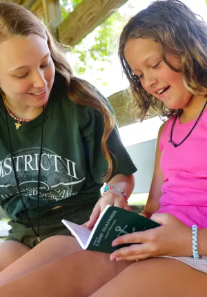 Counselor and camper with green book