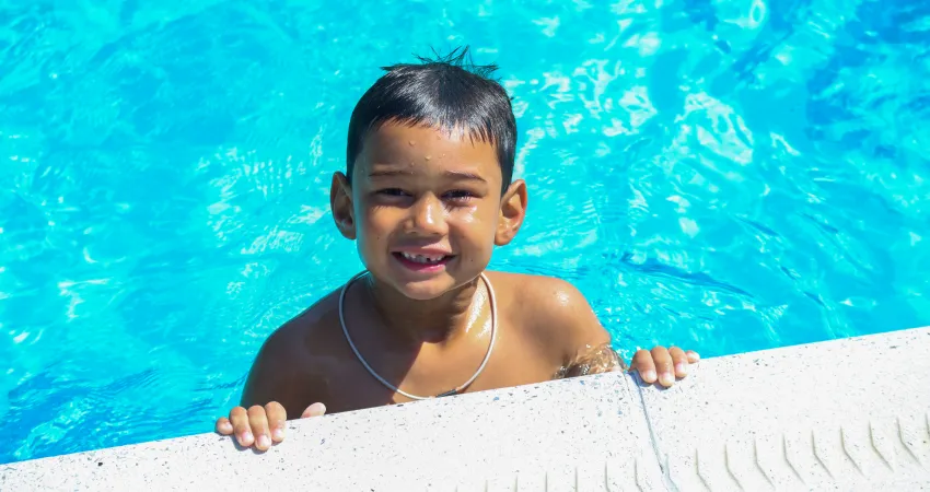 Young boy swimming at the pool in starter camp