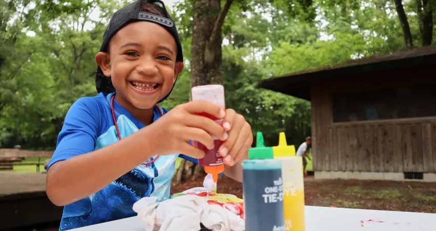 Boy creating a tie dye shirt at Day Camp